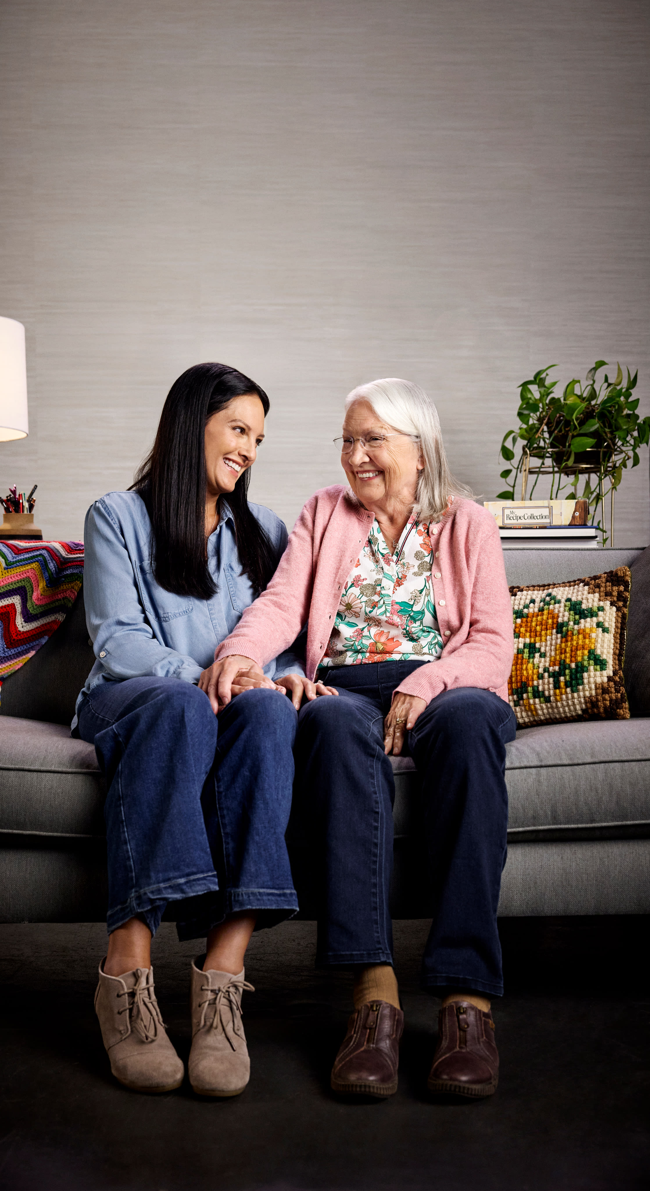 Senior caregiver and elderly woman smiling together
